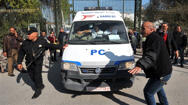 Des membres des forces de l'ordre protègent une ambulance sur les lieux de l'attentat.