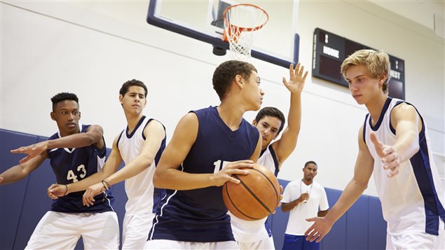 Des jeunes jouent au basketball. 