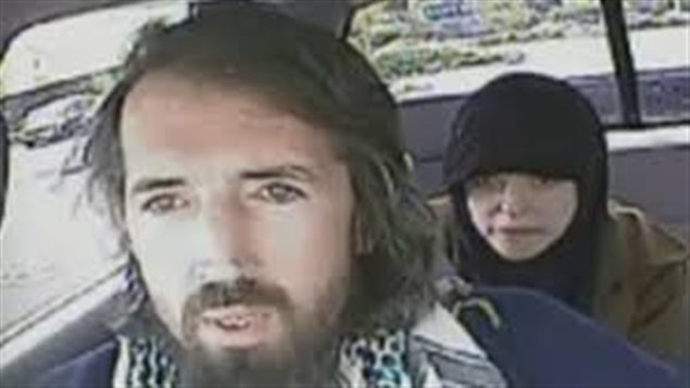 John Nuttall and his wife, Amanda Korody. They are shown in car. Nuttall, bearded and long-haired sits in the front. Korody sits behind him, her head covered.