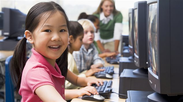 Des enfants du primaire devant des ordinateurs. Plus de 50 % des élèves canadiens de la 6e à la 12e année passe en moyenne plus de deux heures par jour devant un écran électronique.