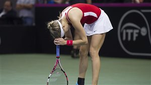 Recend play indicates that Genie Bouchard is not headed in the direction she wasnts to go. We see her bent over at the baseline, knocking the head of her racket against her forehead. She is a picture of frustration, anger and dejection.