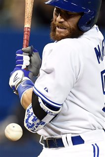 Montrealer Russell Martin is being counted on to bring hard-nosed play and smart catching the Toronto lineup. We see Martin in home whites at the plate flinching as he is about to be hit by a pitch that his heading straight toward is front (left) elbow. He is bearded and intense.
