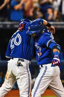 Jose Bautista, right, and Josh Donaldson, left, celebrate a two-run home run hit by Bautista against Atlanta earlier this month. The pair are part of the heart of Toronto's lineup. We see the photo from down the first-base line. Donaldson is wrapping his right arm up around Bautista's right shoulder. Bautista's left hand stretches in the direction of the camera. It resembles a collision but is quite the opposite, an embrace. Each is wearing a blue jersey and white pants.