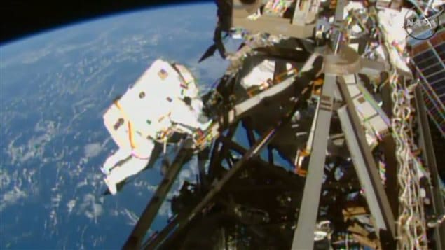 As astronaut (Terry Virts) is seen during a spacewalk outside the International Space Station on March 1. A Canadian company is joining forces with NASA to send hi-def video back from space. With the earth blue and far away in the background, we see an astronaut in a white space suit to the left of the photo. He is working on a wild accumulation of wires and bars. 