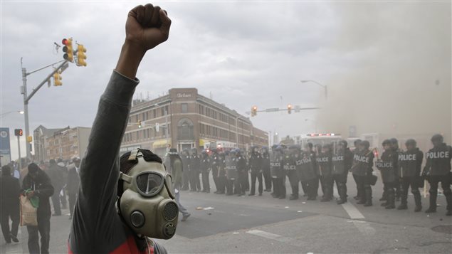 Les policiers et un manifestant avec un masque à gaz