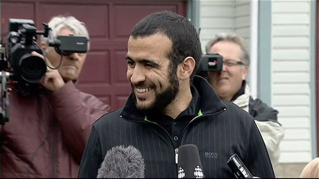 Omar Khadr souriant veut prouvé à la population qu'il n'est pas seulement un nom mais aussi une personne.