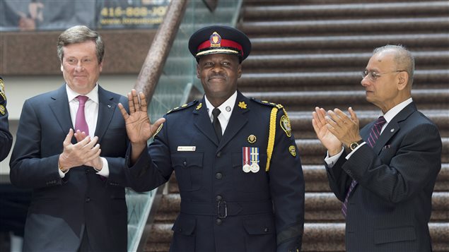 Mark Saunders, Toronto's New Police Chief at the swearing-in ceremony today. He stands between Mayor John Tory and  Alok Mukherjee, chair of the Toronto Police Services Board