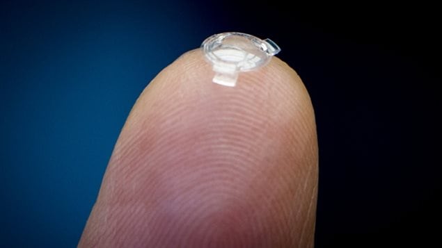 Dr. Webb holds a bionic lens he developed on the tip of his finger. He says a patient's sight would be immediately corrected in a painless procedure, identical to cataract surgery, that would take about eight minutes. 
