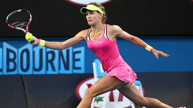  Eugenie Bouchard has had a difficult 2015. She will try to regain her form in Paris, where she was a semi-finalist in 2014. We see her in a pink dress with shoulder straps and yellow cap reaching wide to her forehand side to return a ball at the baseline. She has dark blond hair tied in a single pigtail.