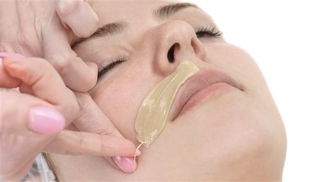 Une femme se fait épiler la moustache. Une femme se fait épiler la moustache.