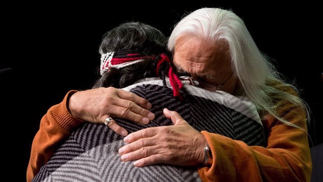 اثنان من سكّان كندا الأصليّين يتعانقان خلال لقاء مع لجنة الحقيقة والمصالحة في فانكوفر