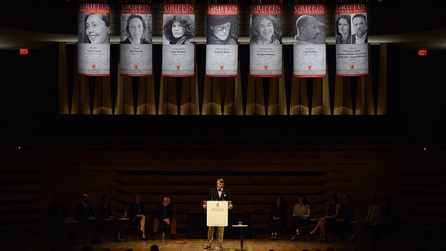 With the signature banners overhead paying tribute to the poets and their works, Scott Griffin warmly welcomes everyone in the packed house to an evening of readings at Koerner Hall at the Royal Conservatory in Toronto in June 2014.