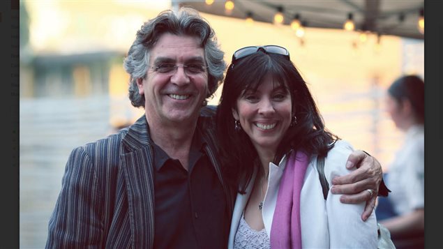 Laurent Imbault and his wife, Katherine Adams, had a vision and it's coming true. We see Imbault on the left, a handsome man with long greying hair and Adams a very attractive brunette. Imbault is hugging Adams with his left hand. Both have wide smiles on their faces.