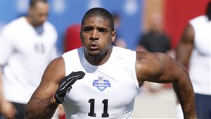 Michael Sam runs through a drill during the NFL Super Regional Combine football workout in Arizona in March. Scouts said at the time he had lost some speed. He went unsigned by the NFL. We see Sam wearing a white a white tee-short with no sleeves running hard toward the camera. He is very powerfully built.
