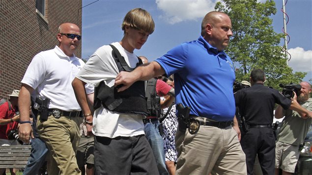 Dylann Roof es escoltado fuera del pouesto de policía de Charleston, el jueves en la tarde.