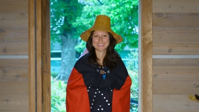 身披红黑色纽扣毛毯、头戴雪松帽子的克里斯蒂娜