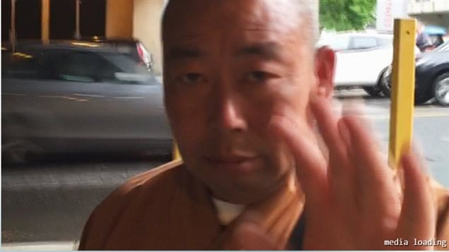 A fake Buddhist monk not wishing to be filmed by a CBC crew in Toronto
