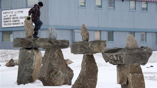 A young boy climbs an inukshuk in April this year in Iqaluit, Nunavut. while Ministers from the eight Arctic nations and the leaders of northern indigenous groups gathered at the Arctic Council Ministerial Meeting in Iqualuit.