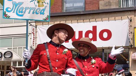 Deux hommes habillés en costumes de la Gendarmerie royale du Canada célèbrent leur mariage lors du défilé de Toronto.