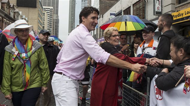 Federal Liberal Leader Justin Trudeau (centre) and Ontario Premier Kathleen Wynne (right) were among the politicians glad-handing during Toronto’s Pride Parade on June 28, 2015.