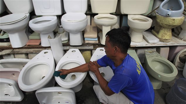 Vendedor de tasas de baño recicladas, en Filipinas. 
