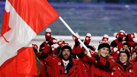 Team Canada proudly waves the Canadian Maple Leaf flag at the Sochi olympics wearing Canada toques voted the most Canadian of clothing items. They also have special Canada mittens and 