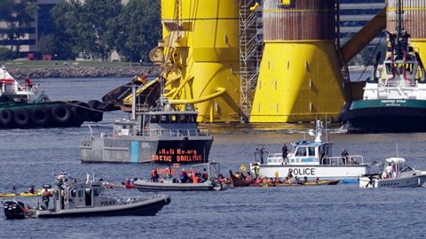 A small flotilla of kayakers and other protest boats are blocked by police as the oil drilling rig Polar Pioneer is towed toward a dock Thursday in Elliott Bay in Seattle. The rig is the first of two drilling rigs Royal Dutch Shell is outfitting for oil exploration and was towed to the Port of Seattle site despite the city's warning that it lacks permits and threats by kayaking environmentalists to paddle out in protes