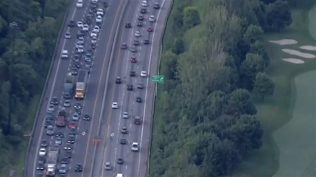 Aerial view of a highways in Toronto. The left lane in each direction (with the painted diamond shapes) has been designated as  only for PanAm games vehicles and commuters with 3 or more peole in their vehicles 