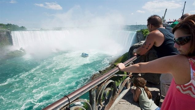 Tourists on the Canadian side watch as the Maid of the Mist tourist boat makes a turn beneath the Canadian Horseshoe Falls. The American side where the drama unfolded is at the left edge of the photo