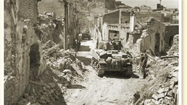 Canadian tanks of the Three Rivers Regiment push through the bitterly contested town of Regalbuto in August 1943.