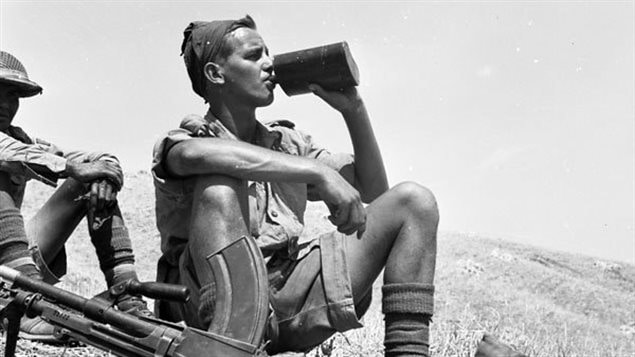 A soldier with the Princess Patricia’s Canadian Light Infantry, 1CID on a hillside near his Bren gun. taking a drink in the obviously hot conditions Valguarnera, Italy, Jul43. 