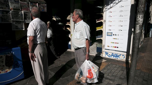 Ciudadanos de Atenas, la capital de Grecia, leen los titulares de la presna local sobre el acuerdo entre Grrecia y los líderes de la Zona Euro. 