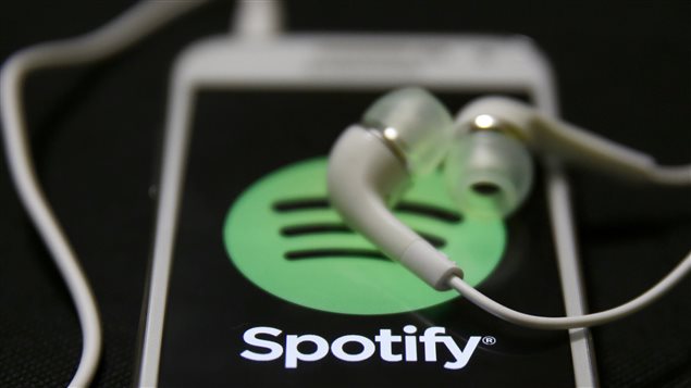 Des écouteurs et un téléphone intelligent branchés sur l’application Spotify