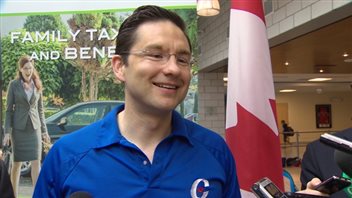 Employment Minister Pierre Poilievre wore the Conservative Party logo when he announced the expanded child care benefits, which appears to break rules designed to keep government and partisan activities separate.