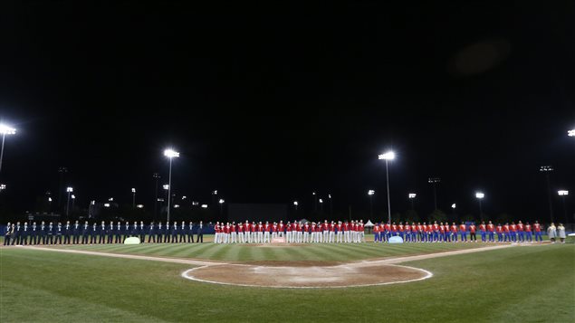 Baseball players from the United States, left, Canada, and Cuba listen to the Canada national anthem during the baseball tournament medal ceremony at the Pan Am Games, Sunday, in Ajax, Ontario.