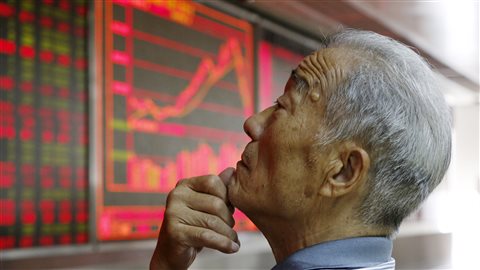 Un investisseur surveille les informations boursières à Pékin.