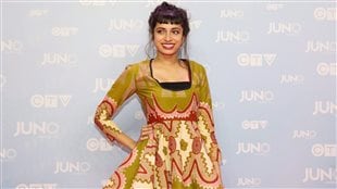 Alysha Brilla poses on the red carpet during the 2015 Juno Awards in Hamilton in March. She has released two self-produced Juno Award nominated albums. We see her standing posed in a gorgeous green, beige and red dress that is marked my many swirls. She obviously knows how to pose as she had a wide smile on her face and is looking off to her right. Her dark hair is up and coifed at the back. She stands in front of a wall marked by several CTV and Juno logos.