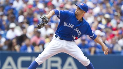 David Price made his Jays debut Monday afternoon against Minnesota and was everything a Toronto fan could hope for. We see Price in the midst of his left-handed delivery with his arm back and his front leg forward. He is dressed in blue uniform top and white pants.