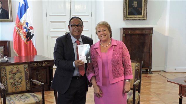 La presidente de Chile, Michelle Bachelet, recibiendo el libro Ton Accent, Luis! (Tu Acento, Luis) escrito por Luis Zúñiga. El libro, una autobiografía, es una incursión en la vida y las dificultades de los inmigrantes. 
