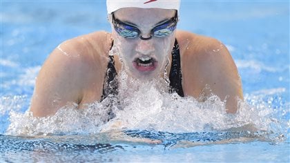 Aurelie Rivard of Canada competes in the women's SB9 breaststroke event on Sunday. She won the silver in the event. Observers say she could become a star of the Games. We see her from the upper chest up. She has extremely powerful shoulders, is wearing googles and a white swimming cap on her head.