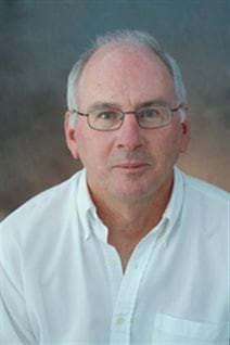 Professor Paul Hebert has set himself a giant task: to get the DNA barcode of all the world's species. We see him in a posed photo in a white dress shirt with the collar open. He wears glasses and his grey hair is receding. He has a look of determination on his face.