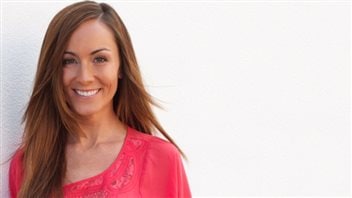 Amanda Lindhout is trying to help Rinelle Harper get to university. We see a lovely woman with long brown hair that drops to her shoulders. Wearing a red dress, she has a gorgeous smile.