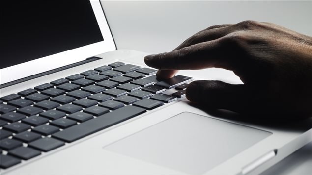 Une main sur un ordinateur.