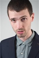 Gonzo Nieto is co-chair of a national alliance called the Canadian Students for Sensible Drug Policy. We see a young man in his 20s with close-cropped brown hair wearing a navy blue sports jacket and a jean-type shirt buttoned to the top of his neck. His head slightly tilted downwards, he looks at the camera from dark brown eyes and the hint of a beard.