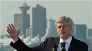 Conservative leader Stephen Harper made a campaign stop at the Vancouver shipyards on Wednesday, a day after he announced an increase of funding for the RCMP to target marijuana grow-ups and meth labs. It's a good photo-op shot. We see Harper dressed in a dark suit, an ultra-white dress shirt and blue tie, which mostly hidden by a pair of microphones. He waves with his right hand as we view the city's skyline behind him.