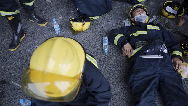 Bomberos en un momento de descanso mientras combatían el incendio en Tianjin. Por lo menos 12 de ellos murieron en las dos explosiones.