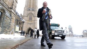 Conservatives are hoping that Irwin Cotler's exit from politics will open the door for them in Mount Royal. We see Cotler dressed in a blue overcoat and grey suit on a winter's day on Parliament Hill. He holds a coffee in his right hand and a newspaper in the other hand. It's a full-length shot, something resembling a vacation photo.