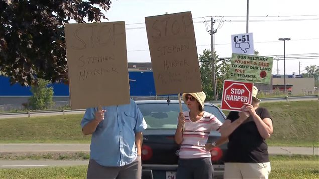Un groupe manifeste contre la réélection de Stephen Harper, à Fredericton, le 17 août.
