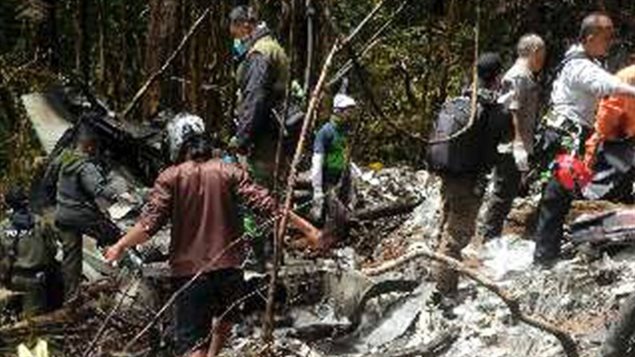 Funcionarios y equipos de rescate en la remota zona del accidente en Penunungan Britang, Papuasia, Indonesia. 