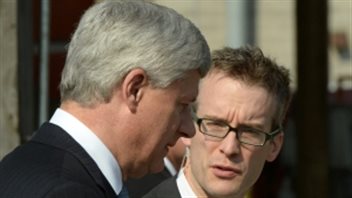 Stephen Harper's current chief of staff Ray Novak (right) was copied on a 2013 email from Nigel Wright about his $90,000 payment to Senator Mike Duffy. We Harper in the foreground with his head bowed conferring witht Novak, wearing designer glasses. It is Novak who appears to be making a point.